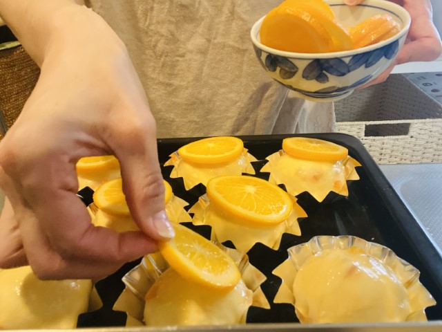 オレンジブレッド；成型カップにれた生地が二次発酵完了し卵を塗った後に輪切りオレンジのせ