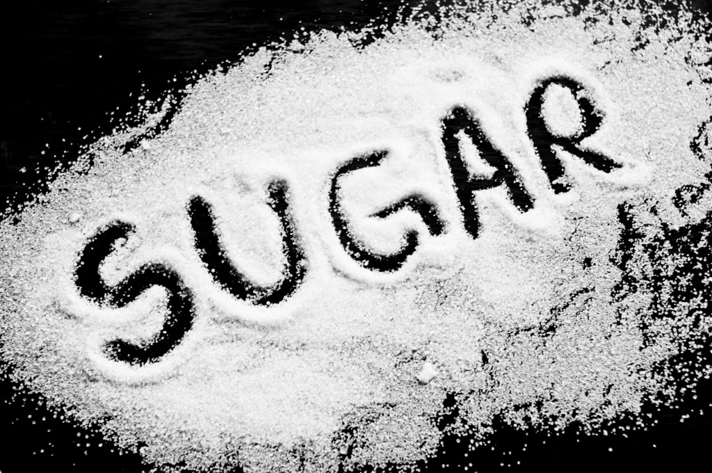 砂糖を広げてsugarの文字を書いている